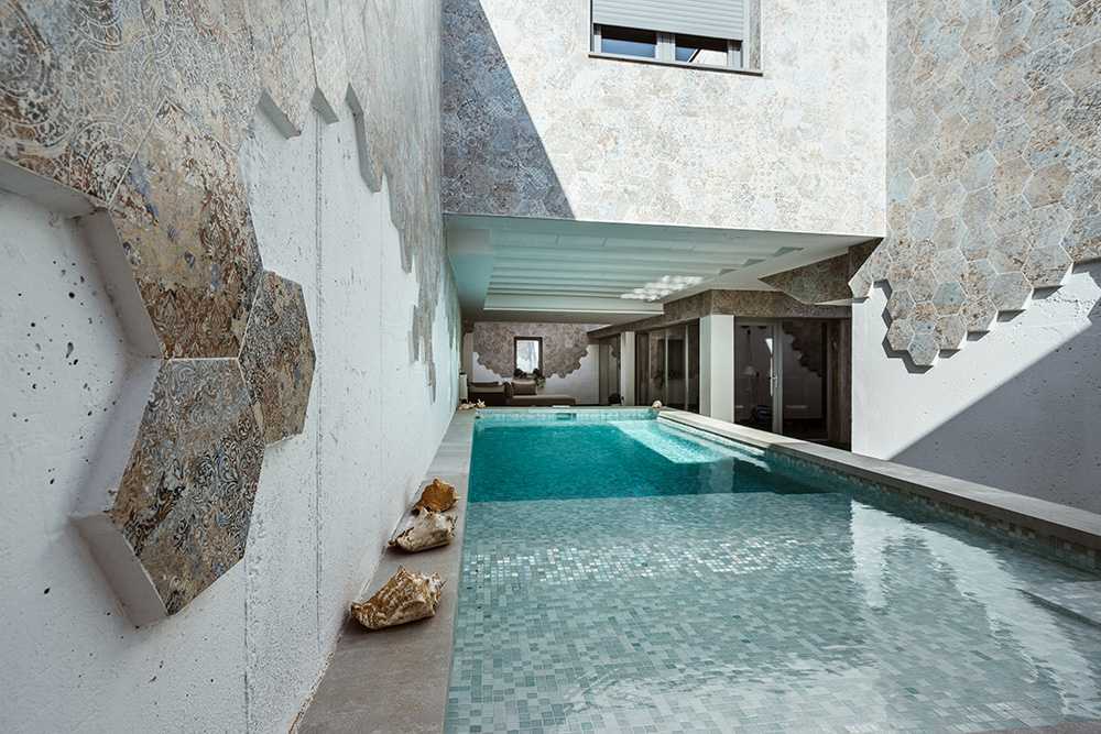 Swimming pool enclosed between the walls of the house